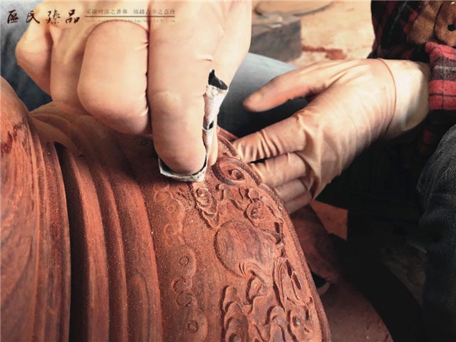 區(qū)氏臻品武大姐用砂紙細(xì)細(xì)打磨鼓凳的雕花