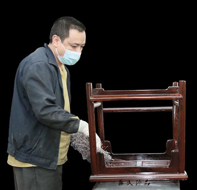區(qū)氏臻品工匠正在對(duì)一件家具仔細(xì)上生漆。這道工序,讓紅木家具一下子有了溫潤(rùn)的質(zhì)感